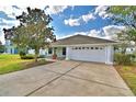 Single story home with attached two car garage and long driveway at 105 Shaddock Dr, Auburndale, FL 33823