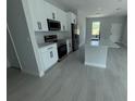 Modern kitchen featuring stainless steel appliances, an island and white cabinetry at 113 Dogwood Drive Circle, Ocala, FL 34472