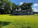 Spacious backyard with green lawn and a view of the house on a sunny day at 1225 Nemeth St, Auburndale, FL 33823