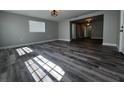 Sunlit living room featuring wood-look floors and a view into the hallway at 1225 Nemeth St, Auburndale, FL 33823