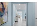 Bright hallway with gray tile floors and artwork on the light-blue walls at 139 Aces High Ln, Davenport, FL 33896