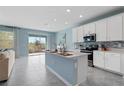 Modern kitchen featuring a large island, stainless steel appliances, and a sliding glass door at 139 Aces High Ln, Davenport, FL 33896