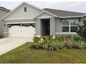 Inviting single-Gathering home featuring a two-car garage, enhanced landscaping, and an attractive entrance at 1827 Silverbell Loop, Haines City, FL 33844