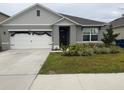 Attractive single-story home features an attached garage, decorative landscaping, and a welcoming front entrance at 1827 Silverbell Loop, Haines City, FL 33844