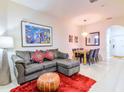 Stylish living room with a comfortable sectional sofa, colorful art, and a bright dining area at 2725 Coupe St, Kissimmee, FL 34746