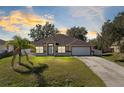 Charming single-story home featuring a well-manicured lawn, attached garage, and welcoming front entrance at 2938 Foraker Way, Kissimmee, FL 34758