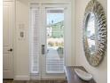 Bright entryway with white door, modern mirror and stylish console table at 2980 Caribbean Soul Dr, Kissimmee, FL 34747