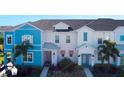 Inviting home exterior featuring colorful siding, a well-maintained lawn, and lush, tropical landscaping at 2980 Caribbean Soul Dr, Kissimmee, FL 34747