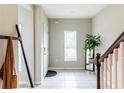 Bright entryway featuring tile flooring, coat rack, and staircase leading to the upper level at 4823 Coral Castle Dr, Kissimmee, FL 34746