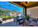 Relaxing screened lanai with dining table and chairs overlooking the beautiful backyard at 507 Pamplona Pl, Davenport, FL 33837