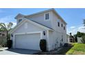 Two-story home featuring a two-car garage, neutral paint, and manicured landscaping at 525 Garberia Dr, Davenport, FL 33837