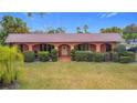 Lovely brick home with a well-manicured lawn and hedge landscaping along the front porch at 6 Palm Way, Haines City, FL 33844