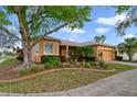 Charming single-story home with a mature tree, and colorful landscaping at 651 Glendora Rd, Kissimmee, FL 34759