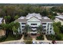 Aerial view showcases building's balconies, brick accents, and palm-lined facade at 7660 Whisper Way # 104, Reunion, FL 34747