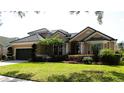 Charming one-story home features lush landscaping, a well-manicured lawn, and a tile roof at 7670 Milano Dr, Orlando, FL 32835