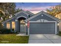 Beautiful gray single-Gathering home with garage, arched entryway, and manicured lawn, under a colorful sky at 816 Garden Glen Loop, Lake Mary, FL 32746