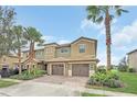 Inviting two-story townhome featuring a brick driveway and attached two-car garage at 8946 Azalea Sands Ln # 8946, Davenport, FL 33896