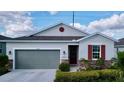 Charming single-story home with a gray garage door, stone accents, and inviting front entrance at 1042 Heirloom Dr, Haines City, FL 33844