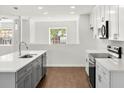 Modern kitchen with gray cabinets, stainless steel appliances, and wood tile flooring at 1062 Hidden Dr, Lakeland, FL 33809