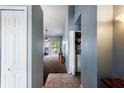 View from the entry hall of the living room with tiled floors, closet, washer, dryer and sliding glass doors at 13829 Timberland Dr # 204, Orlando, FL 32824