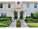 Close-up of condo entrances shows tidy front landscaping and walkway at 1554 Plunker Dr, Davenport, FL 33896