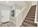 Entryway with tile floor, art, staircase, and white front door at 1554 Plunker Dr, Davenport, FL 33896
