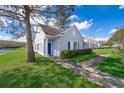 Charming single-story home with a blue door and shutters, complemented by lush landscaping and water view at 2022 Island Walk Dr, Orlando, FL 32824
