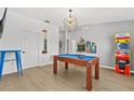 Entertainment room with a wooden pool table, classic arcade game, cool light fixture, and bright flooring at 3137 Sun Lake Ct # B, Kissimmee, FL 34747