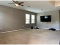 Spacious living room featuring neutral carpet, ceiling fan, and multiple windows for natural light at 3742 Maidencain St, Clermont, FL 34714