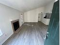 Open-concept living room with a vaulted ceiling, fireplace, and wood-look floors and access to kitchen area at 4200 Thornbriar Ln # 208, Orlando, FL 32822
