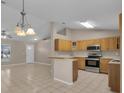 An open-concept kitchen with stainless steel appliances, tile flooring, and a breakfast bar at 4815 Doc Dr, St Cloud, FL 34771