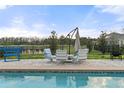 Outdoor lounge area by the pool with comfortable seating and scenic views of the surrounding landscape at 6808 Cranes Roost Rd, Harmony, FL 34773