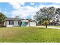 Single story home with painted brick, attached garage, and blue accents on the front porch at 725 Montana Ave, St Cloud, FL 34769