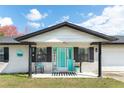 Inviting front porch with turquoise door, classic rocking chair, and stylish accents enhancing curb appeal at 725 Montana Ave, St Cloud, FL 34769