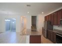 Well-lit kitchen featuring granite countertops, stainless steel appliances and island with sink at 7381 Alpine Butterfly Ln, Orlando, FL 32819