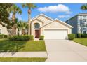Well-manicured lawn with palm trees complements this beautiful single-Gathering home with an attached garage at 8595 Sunrise Key Dr, Kissimmee, FL 34747
