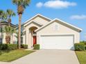 Well-manicured lawn with palm trees complements this beautiful single-Gathering home with an attached garage at 8595 Sunrise Key Dr, Kissimmee, FL 34747