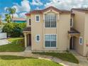 Charming condo featuring a traditional facade with a tiled roof and manicured lawn at 8708 Papaya Dr, Kissimmee, FL 34747