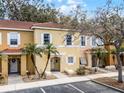 Two-story condo featuring lush landscaping, neutral tones, and a well-maintained exterior at 1007 Park Ridge Cir, Kissimmee, FL 34746