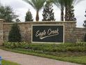 Stone community entrance sign for Eagle Creek, enhanced with manicured landscaping and mature palm trees at 10467 Henbury St, Orlando, FL 32832