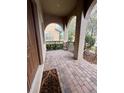 Inviting covered porch featuring brick flooring, neutral columns, and decorative railing creating a cozy outdoor space at 10467 Henbury St, Orlando, FL 32832