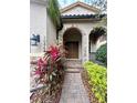 Charming home entrance with a stone archway, brick path, and lush landscaping adding to the curb appeal at 10467 Henbury St, Orlando, FL 32832