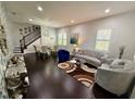 Elegant living room featuring a modern sofa, unique decor, dark hardwood floors, and staircase at 10467 Henbury St, Orlando, FL 32832