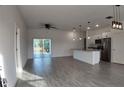 Bright open-concept living room and kitchen with gray wood-look tile and modern pendant lighting at 1313 Congo Dr, Kissimmee, FL 34759