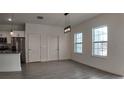 Spacious living area featuring wood-look tile, two windows, two doors, and modern lighting at 1313 Congo Dr, Kissimmee, FL 34759