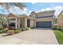 Beautifully landscaped home featuring a paved driveway, lush lawn, and a two-car garage at 13258 Vennetta Way, Windermere, FL 34786