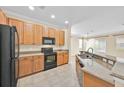 Bright kitchen featuring stainless steel appliances, granite countertops, and wood cabinets at 1518 Orrington Payne Pl, Casselberry, FL 32707
