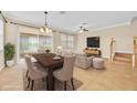 Open-concept living room with a dining table, comfortable sofa, and sliding glass doors offering seamless indoor-outdoor living at 1518 Orrington Payne Pl, Casselberry, FL 32707
