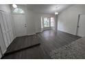 Open living room featuring modern gray wood-look floors, bright natural light, and neutral color palette at 3216 Fieldcrest Ter, Deltona, FL 32725