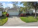 Inviting home exterior showcasing a well-maintained lawn, mature trees, and a convenient two-car garage at 4086 Kingsley St, Clermont, FL 34711